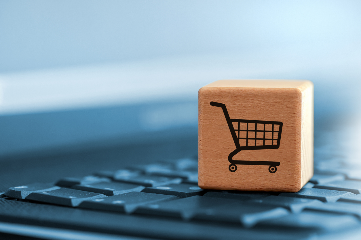 Cube with shopping trolley symbol on the laptop keyboard
